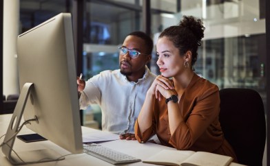 Two employees working at computer