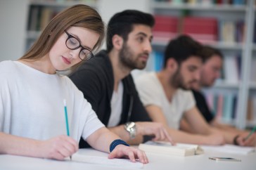 Adults in class learning, writing
