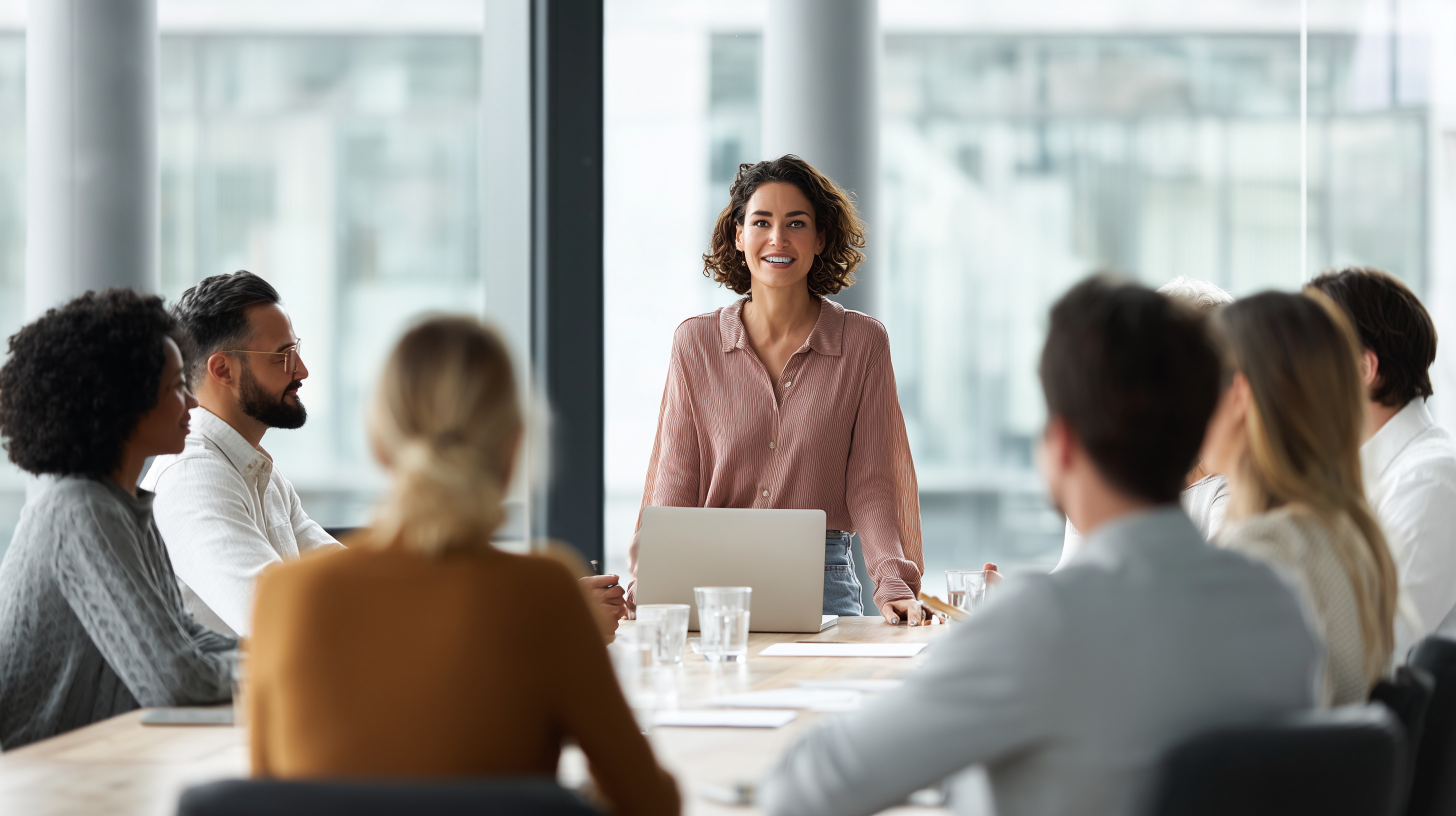 Woman speaking to employees at conference table