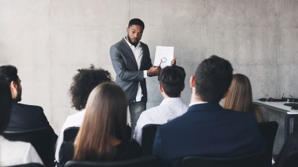 Man explaining chart to roomful of professionals