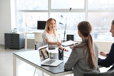 Young woman handing papers in job interview