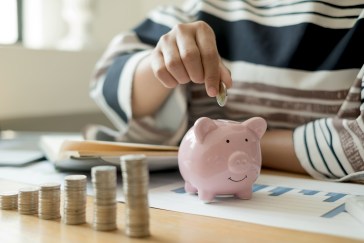 Woman putting money in a piggy bank