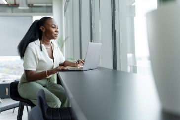 Woman sitting at a table with her computer