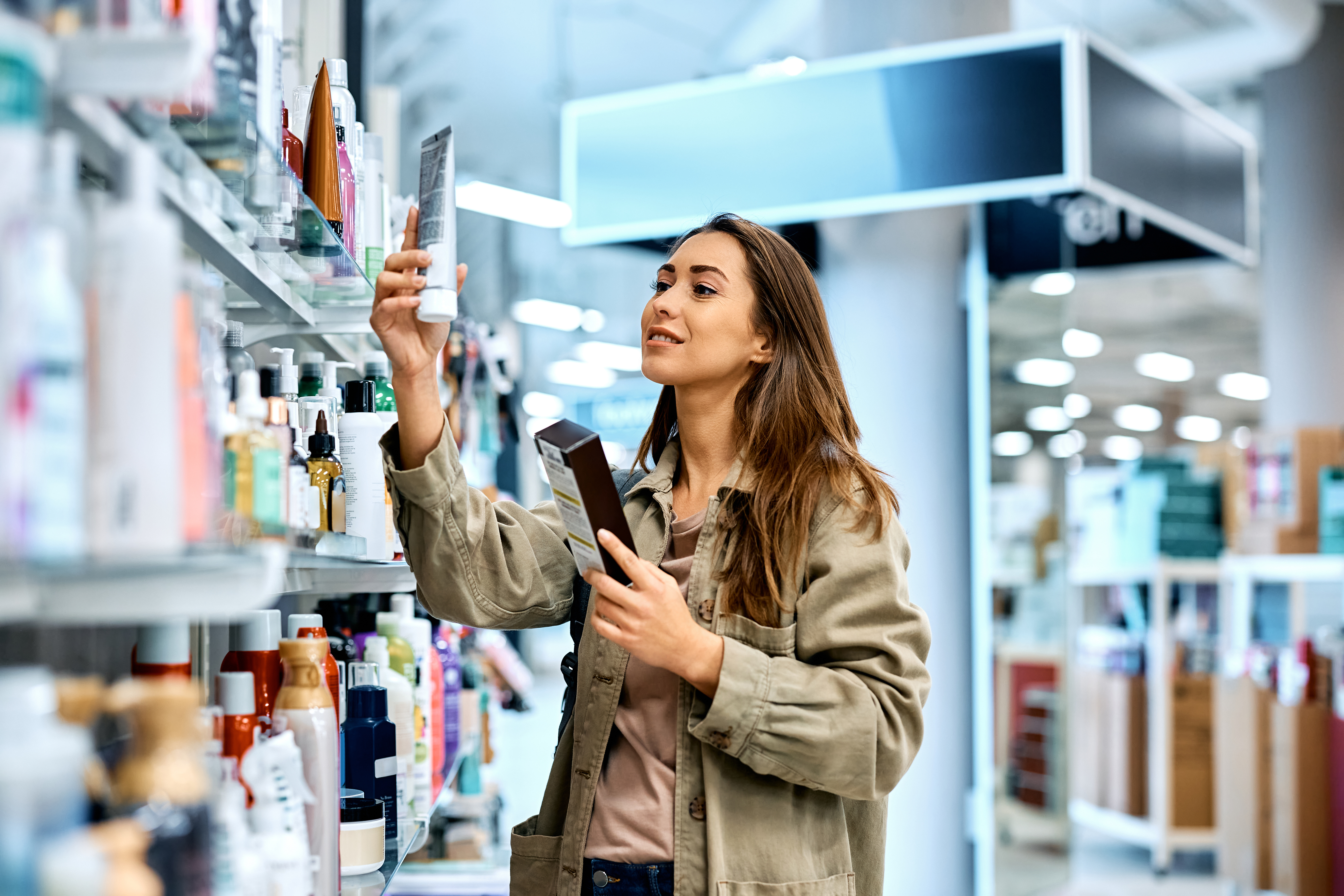 Woman looking at bottle in pharmacy aisle