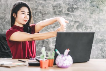 Woman stretching at her desk