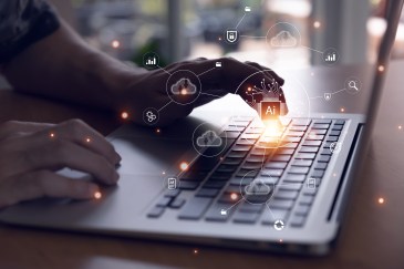 Person typing on a keyboard with AI icons