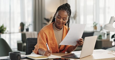 Woman working at desk, holding paper