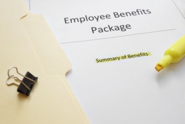 A folder rests on a table next to a paper titled, "Employee Benefits Package."