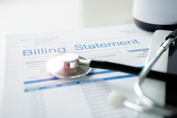 A billing statement for health care expenses rests on a table.