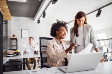 Women looking over documents at work