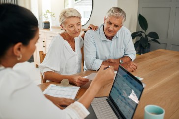 A retirement planner talks to a couple.