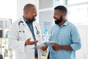 Male doctor speaking with male patient, smiling