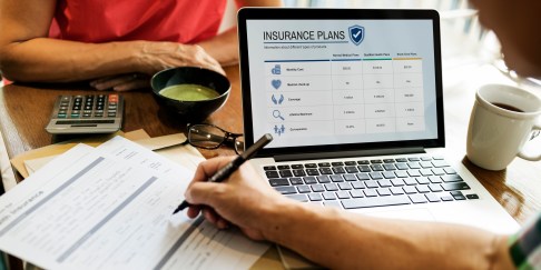 A person looks at healthcare plans on a computer.