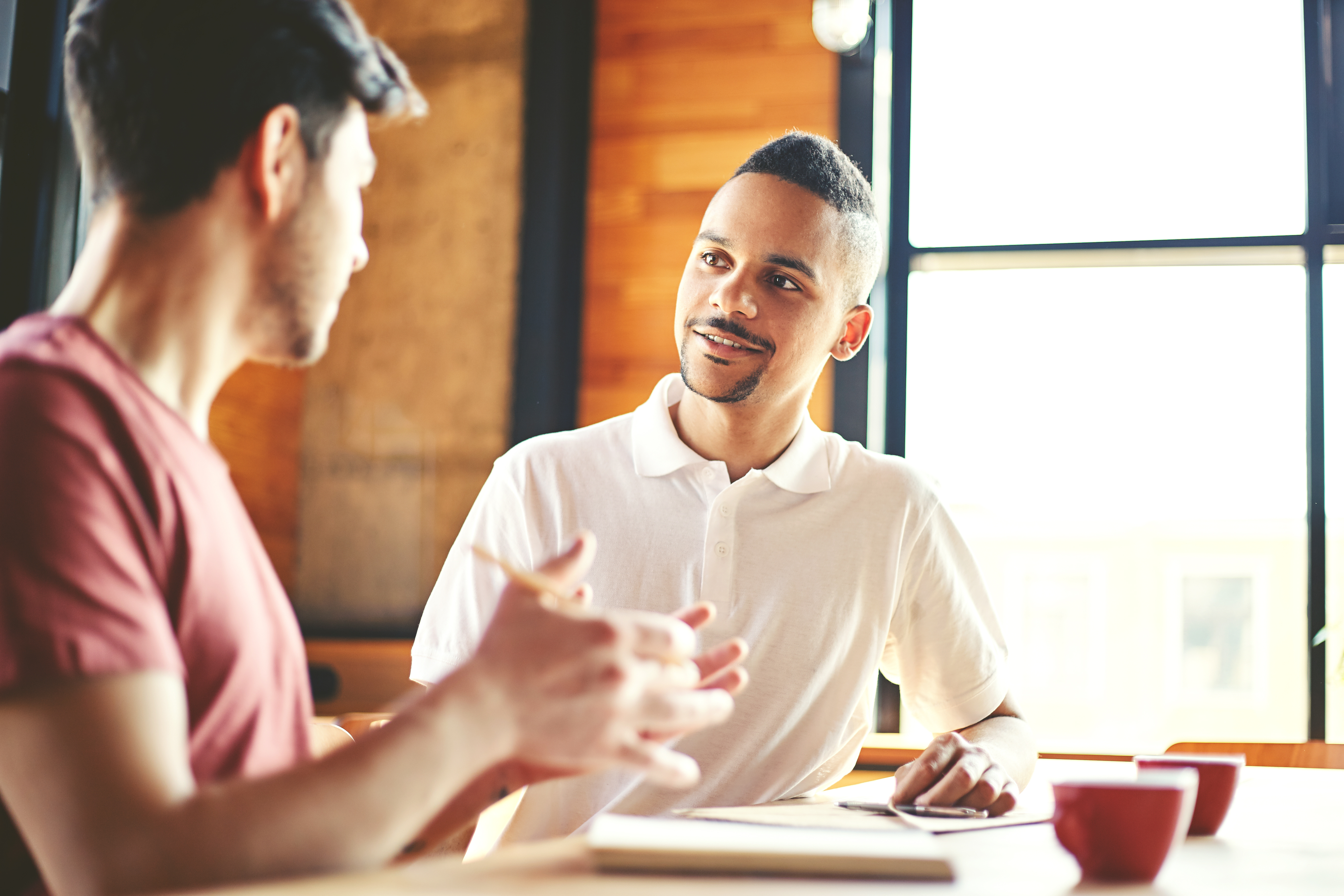 Two male coworkers talking