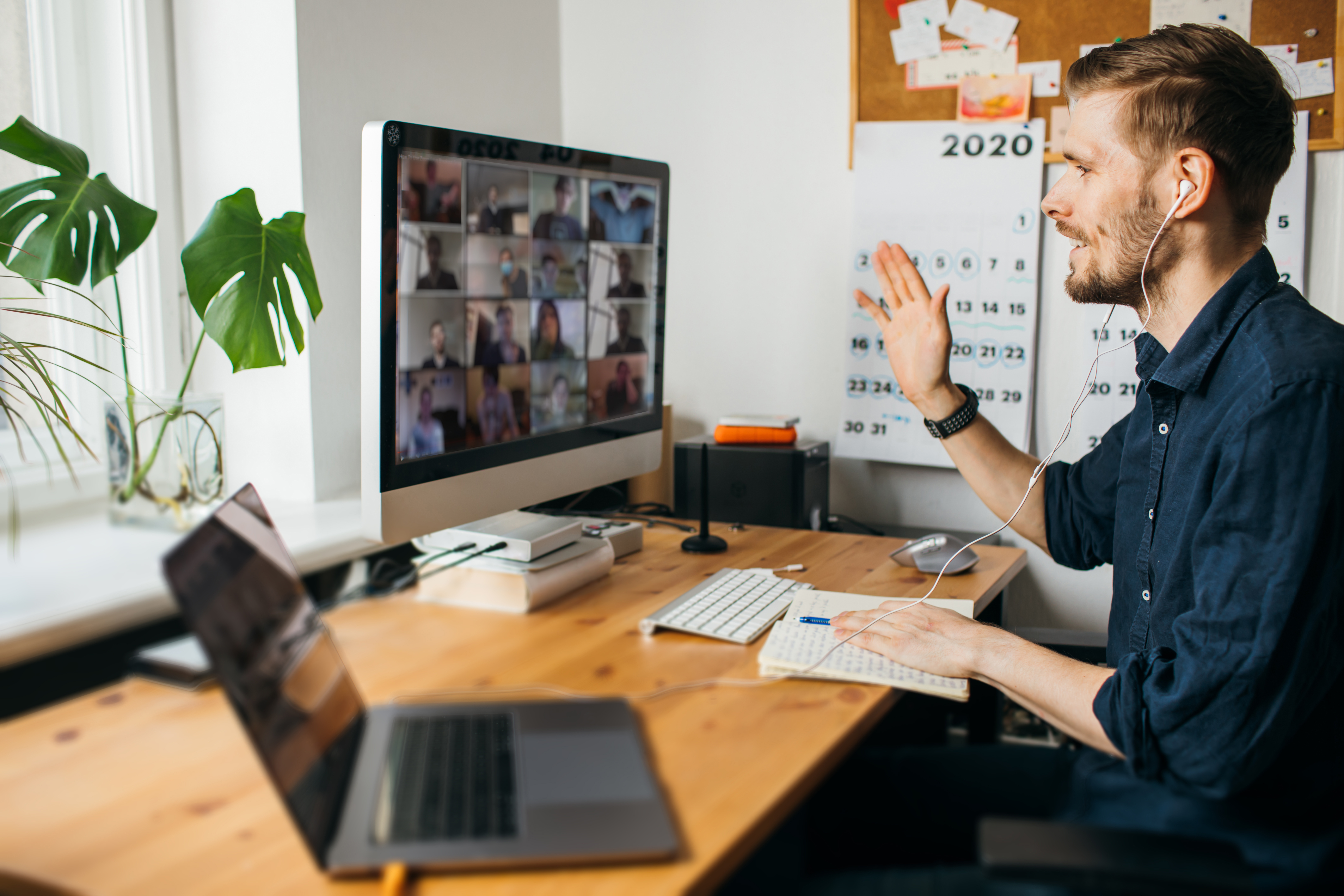 A man working from home attends a Zoom meeting.