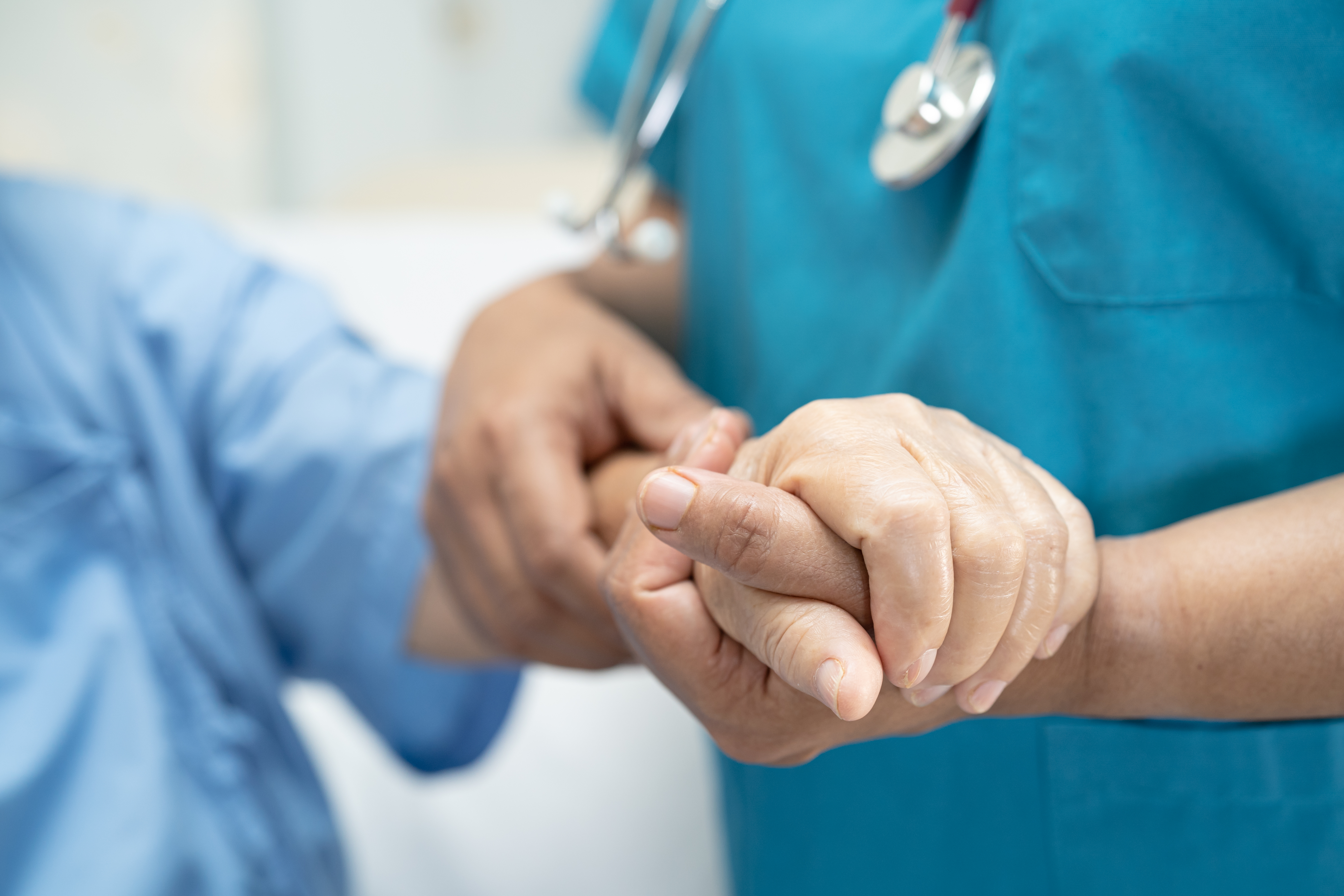 Nurse holding a patient's hand