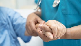 Nurse holding a patient's hand