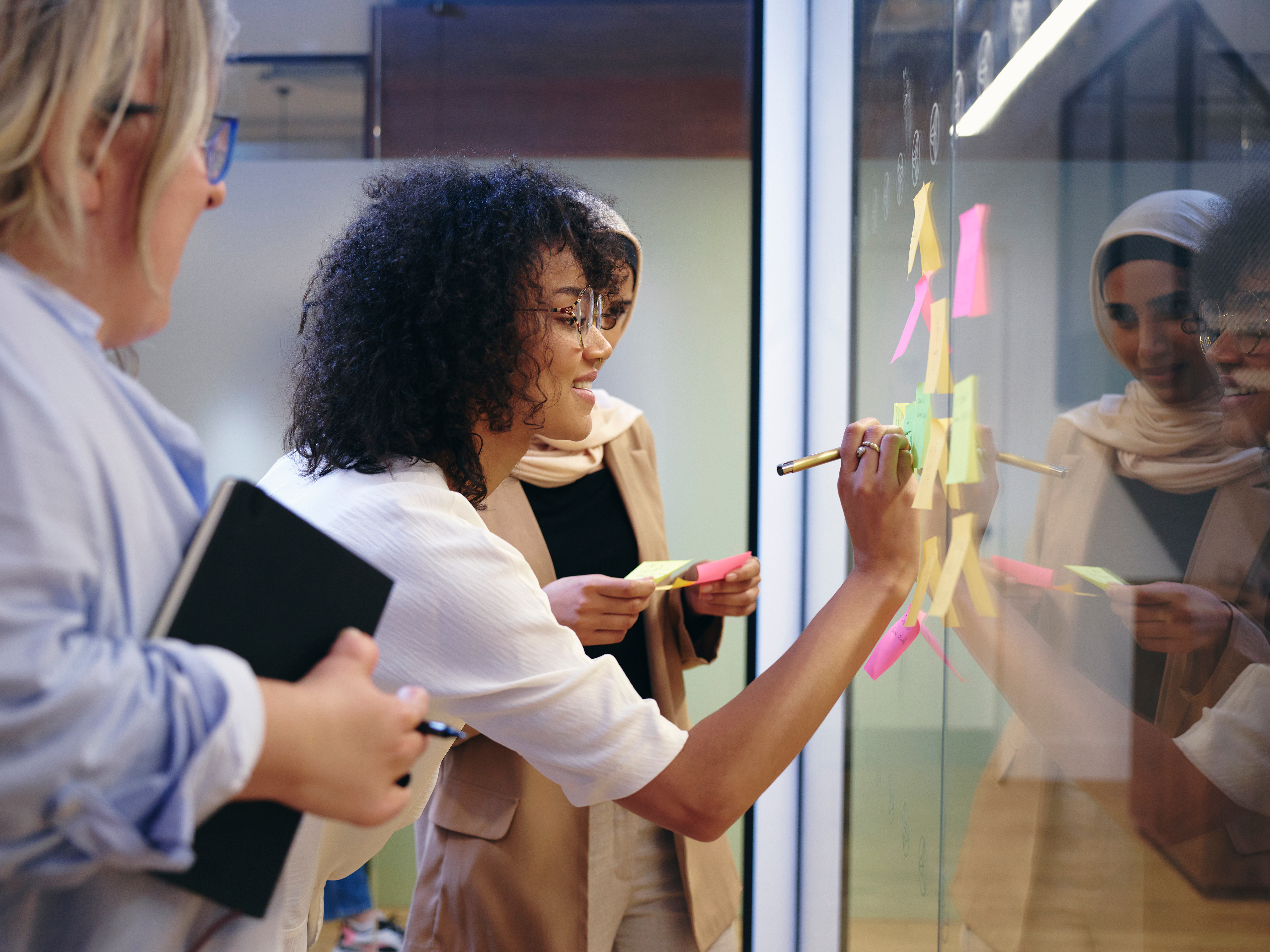A woman makes notes on a big board.
