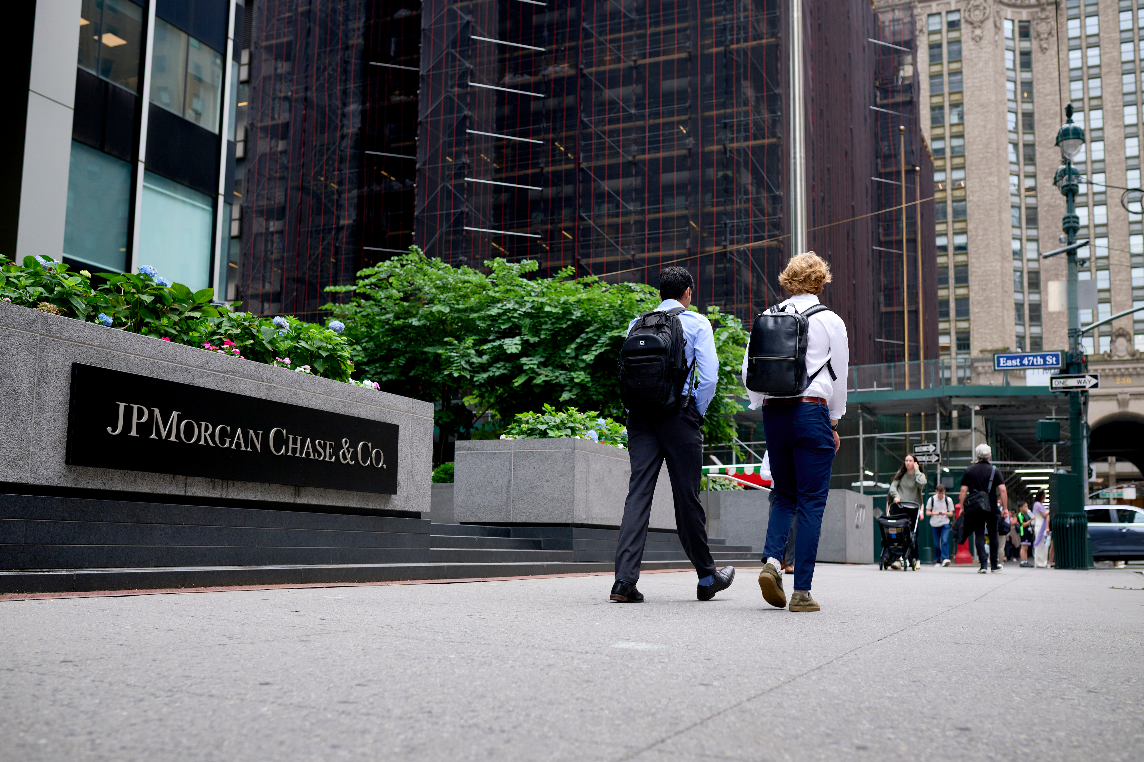 Two young men walking by JPMorgan office building