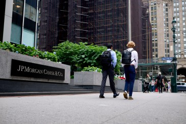Two young men walking by JPMorgan office building