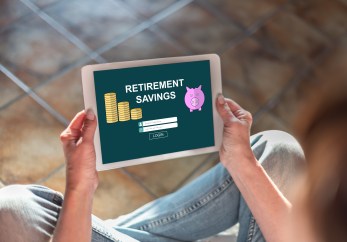 A person holds a mobile device that says "Retirement Savings" on the screen.