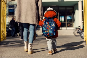 Mother walking child into school, daycare