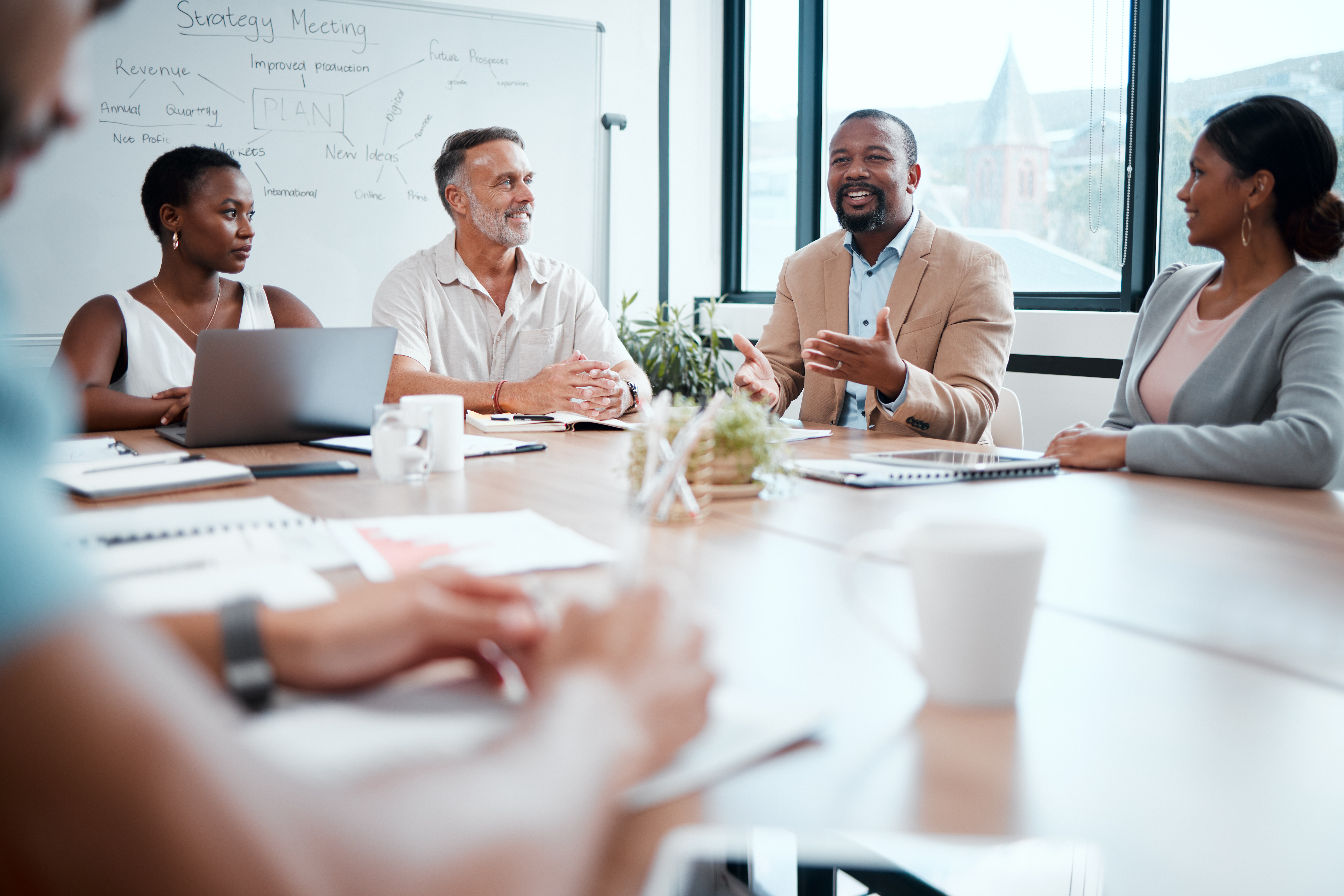Group of employees speaking around table