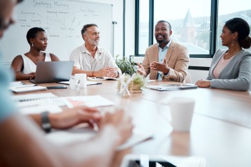 Group of employees speaking around table