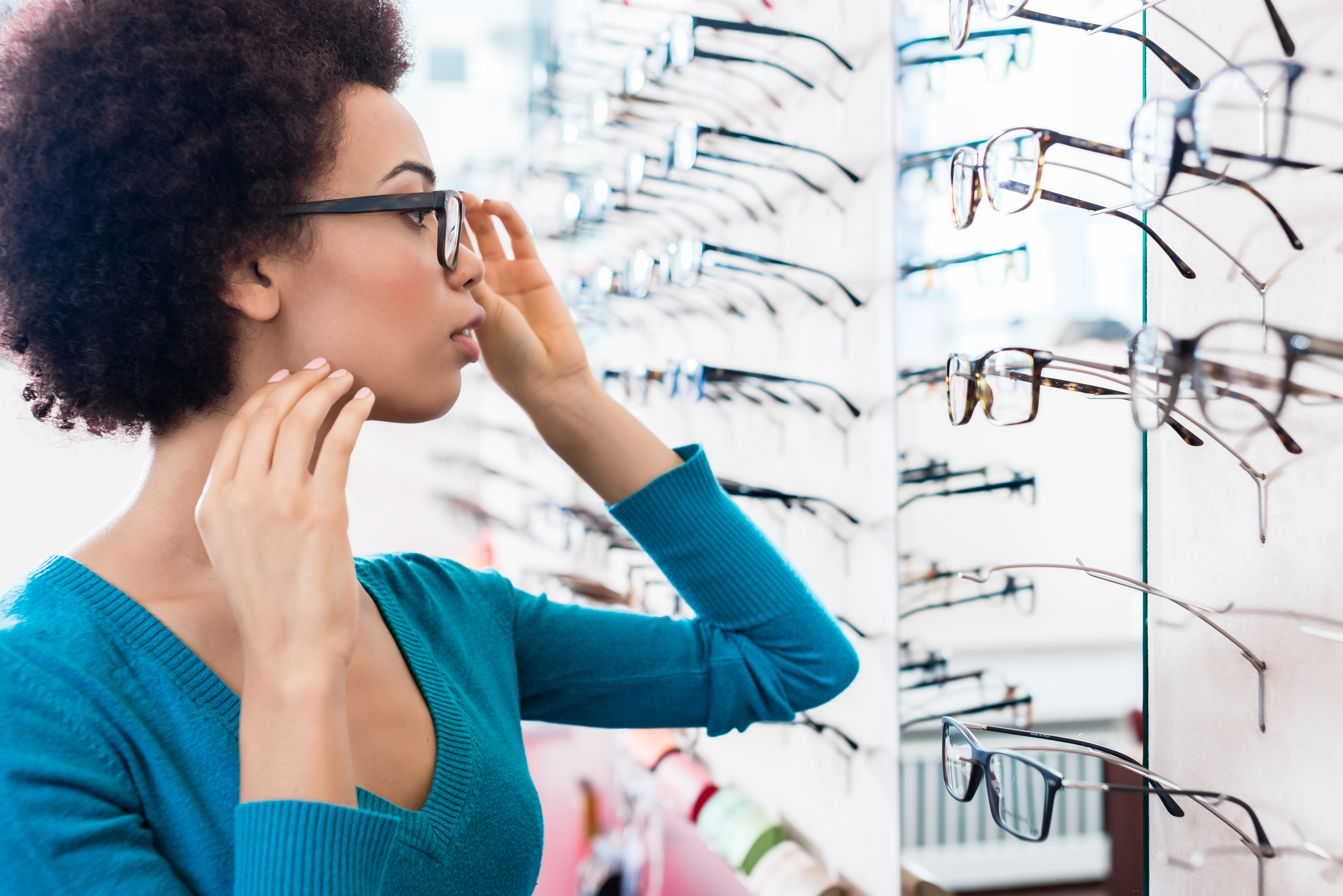 Woman trying on glasses in store
