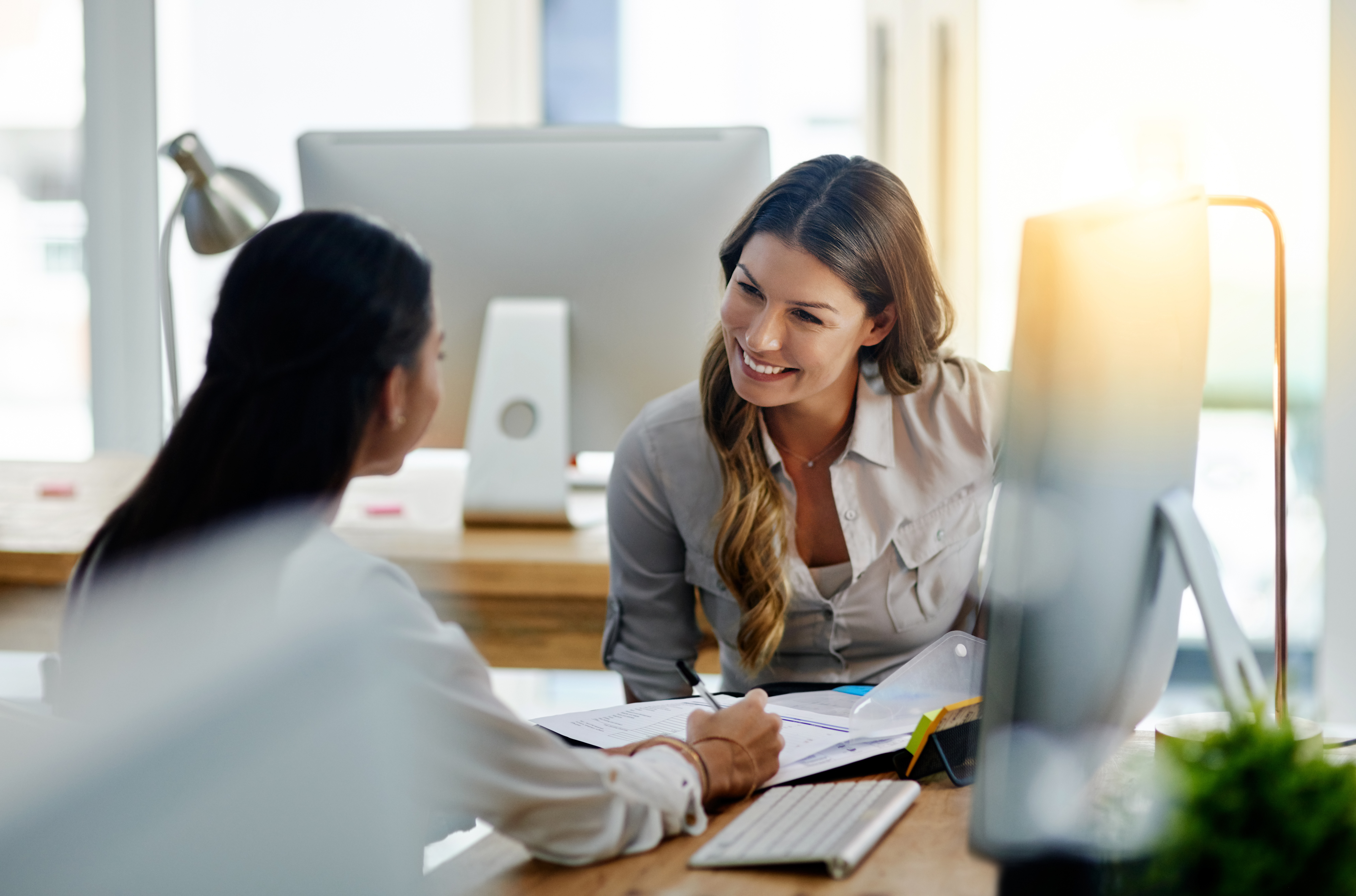 Two women talking to each other in office