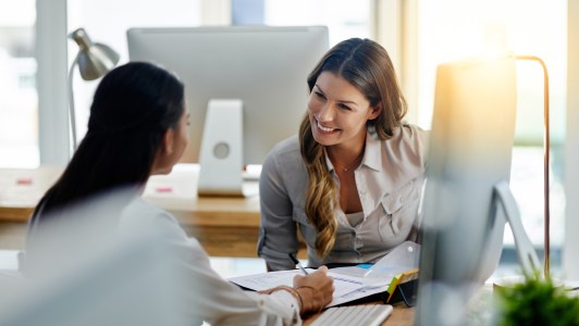 Two women talking to each other in office