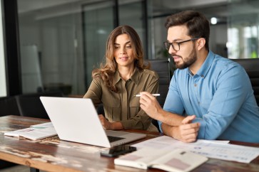 Two employees working on computer together