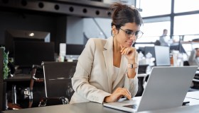 Woman sitting at desk working on laptop