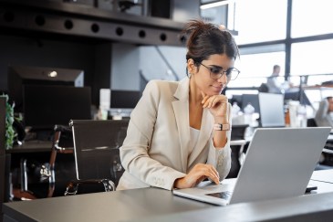 Woman sitting at desk working on laptop
