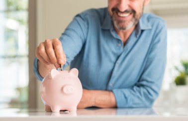 Man putting coin in piggy bank