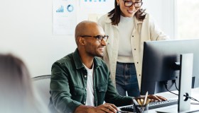 Two employees looking at computer