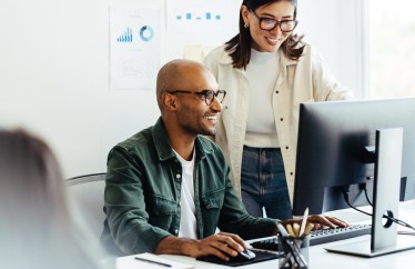 Two employees looking at computer