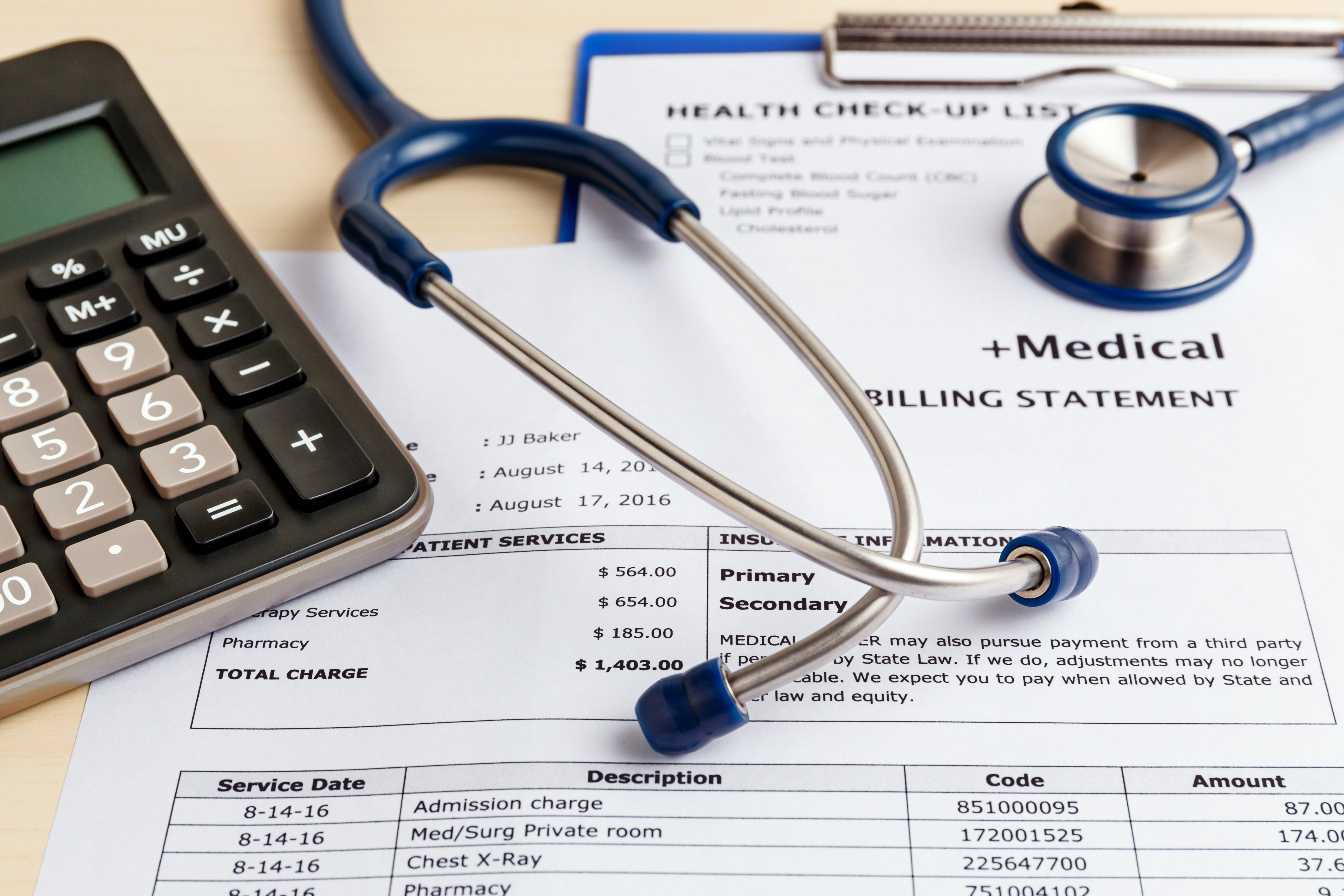 Medical cost concept with calculator and stethoscope.