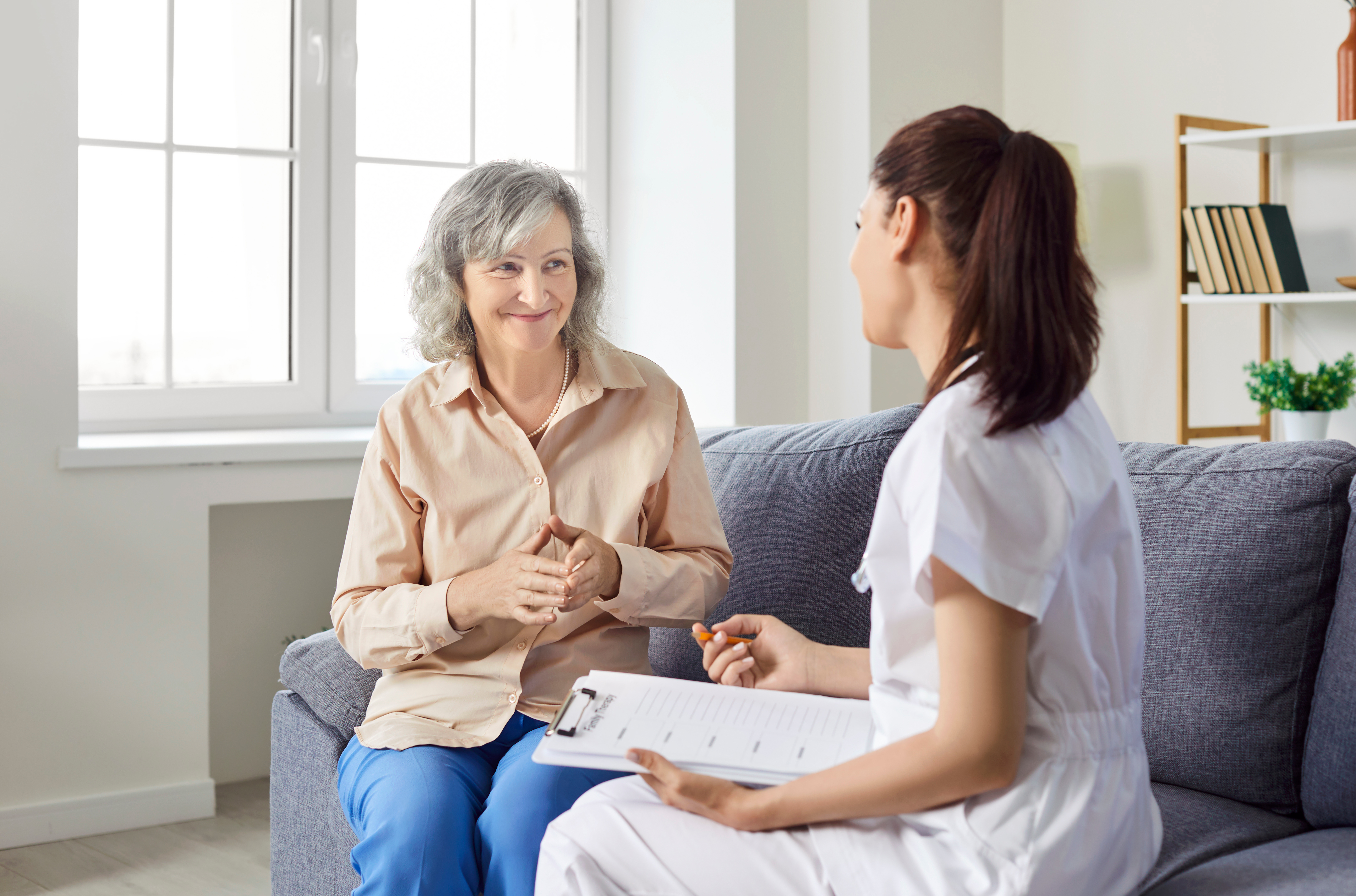 Caring kind nurse, geriatric medicine caretaker asking old woman nursing home resident, senior adult in assisted living, female doctor visiting patient, caregiving service, aid worker helping, sharing.