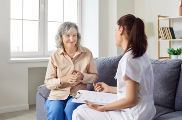 Caring kind nurse, geriatric medicine caretaker asking old woman nursing home resident, senior adult in assisted living, female doctor visiting patient, caregiving service, aid worker helping, sharing.