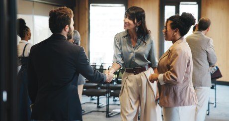 Man and woman shaking hands at work, in office