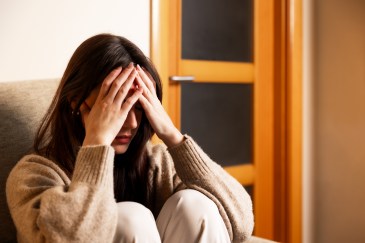 Woman experiencing stress, headache, and mental health issues.
