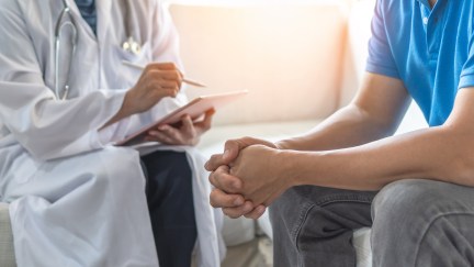 Doctor speaking with patient, hands folded
