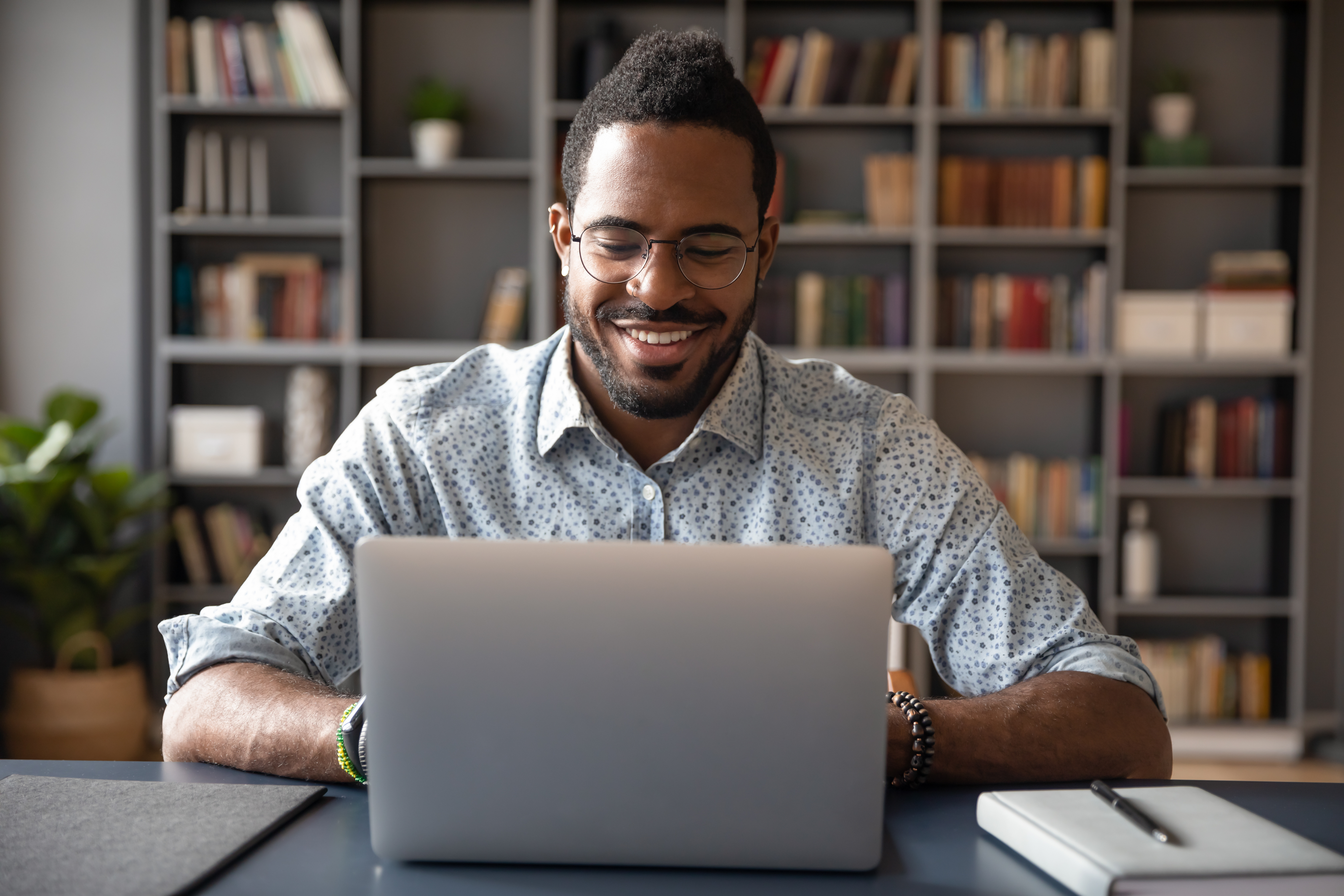 Man working on laptop, smiling