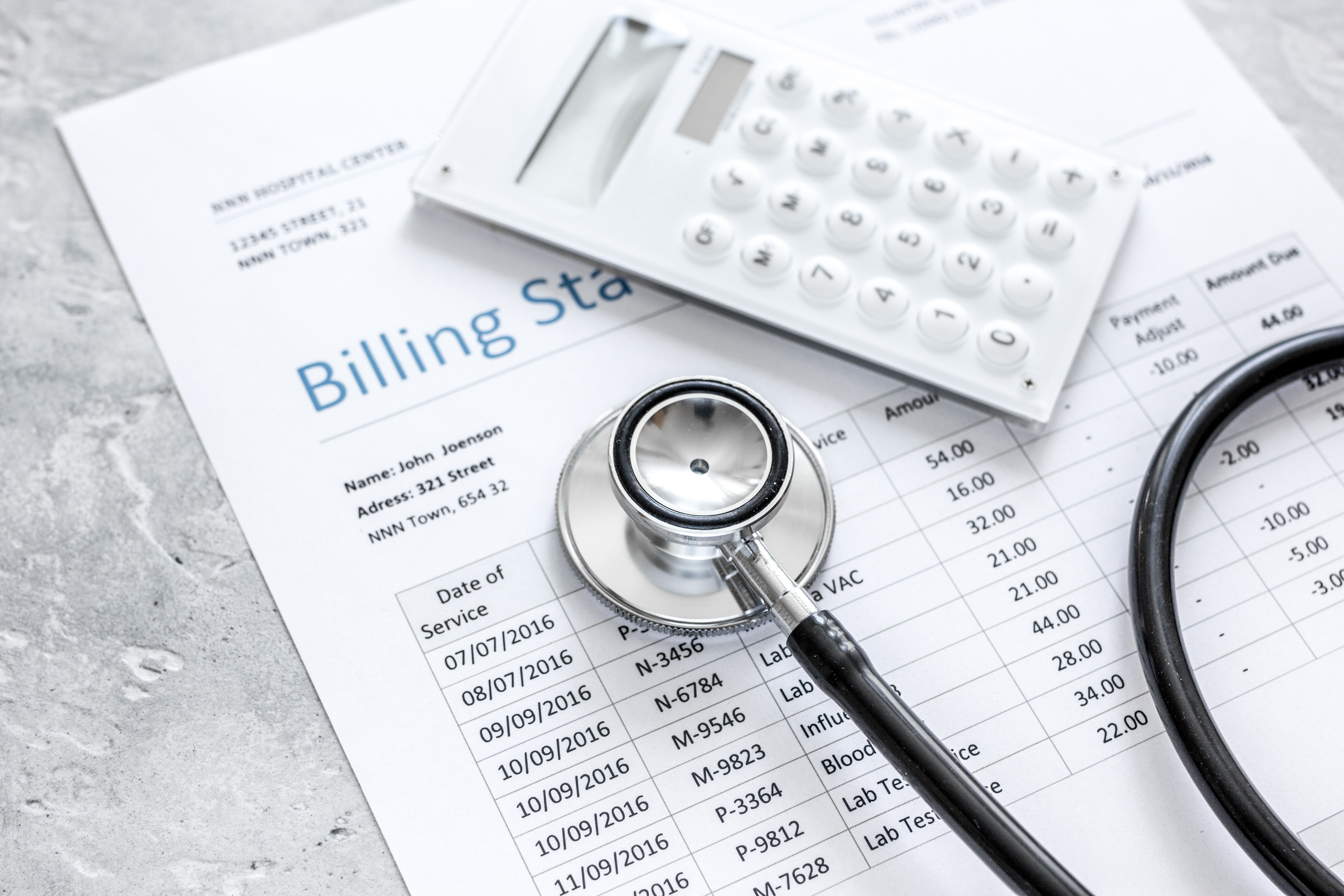 Medical billing statement, stethoscope and calculator