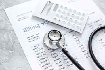 Medical billing statement, stethoscope and calculator