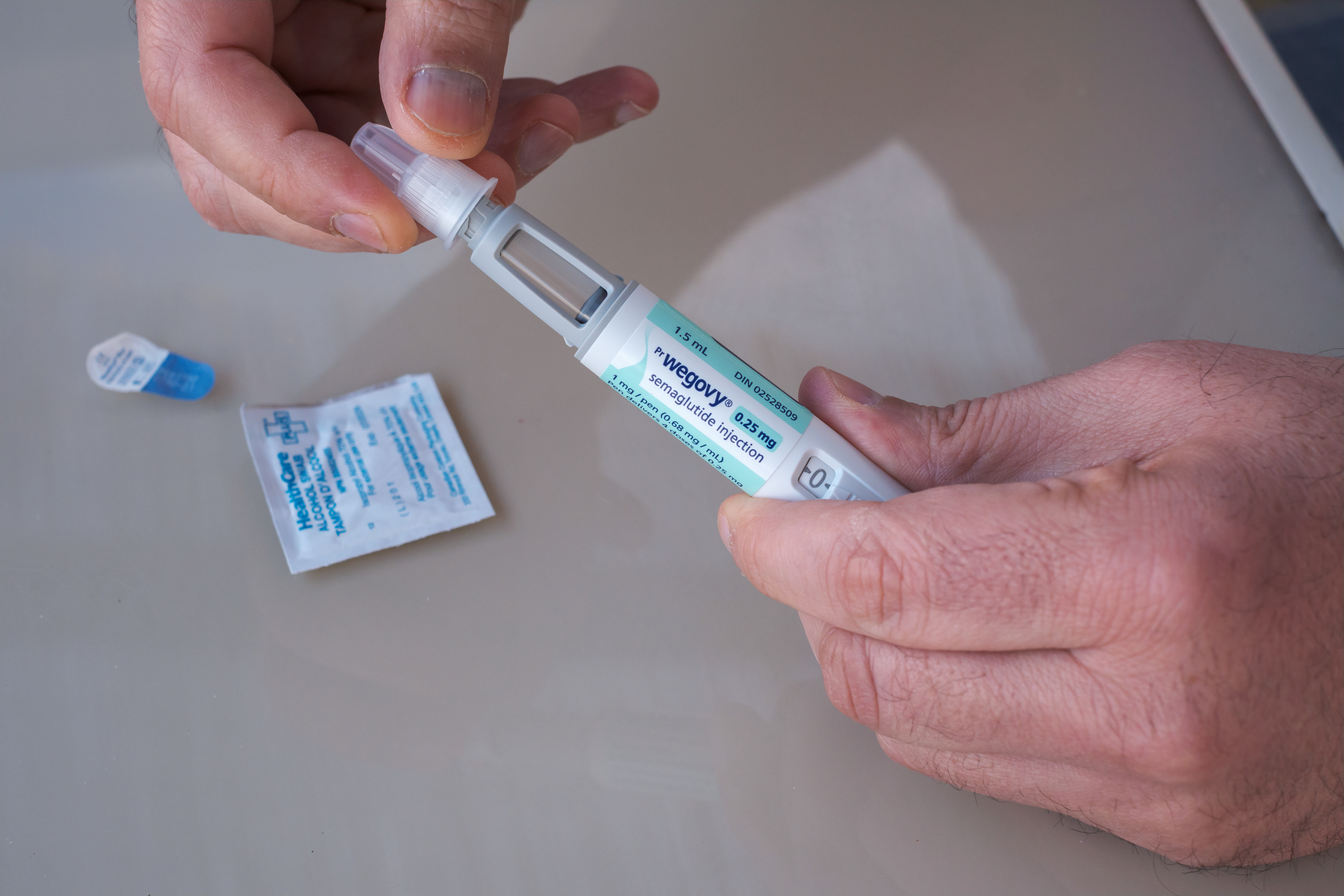Man's hands holding Wegovy GLP-1 injection