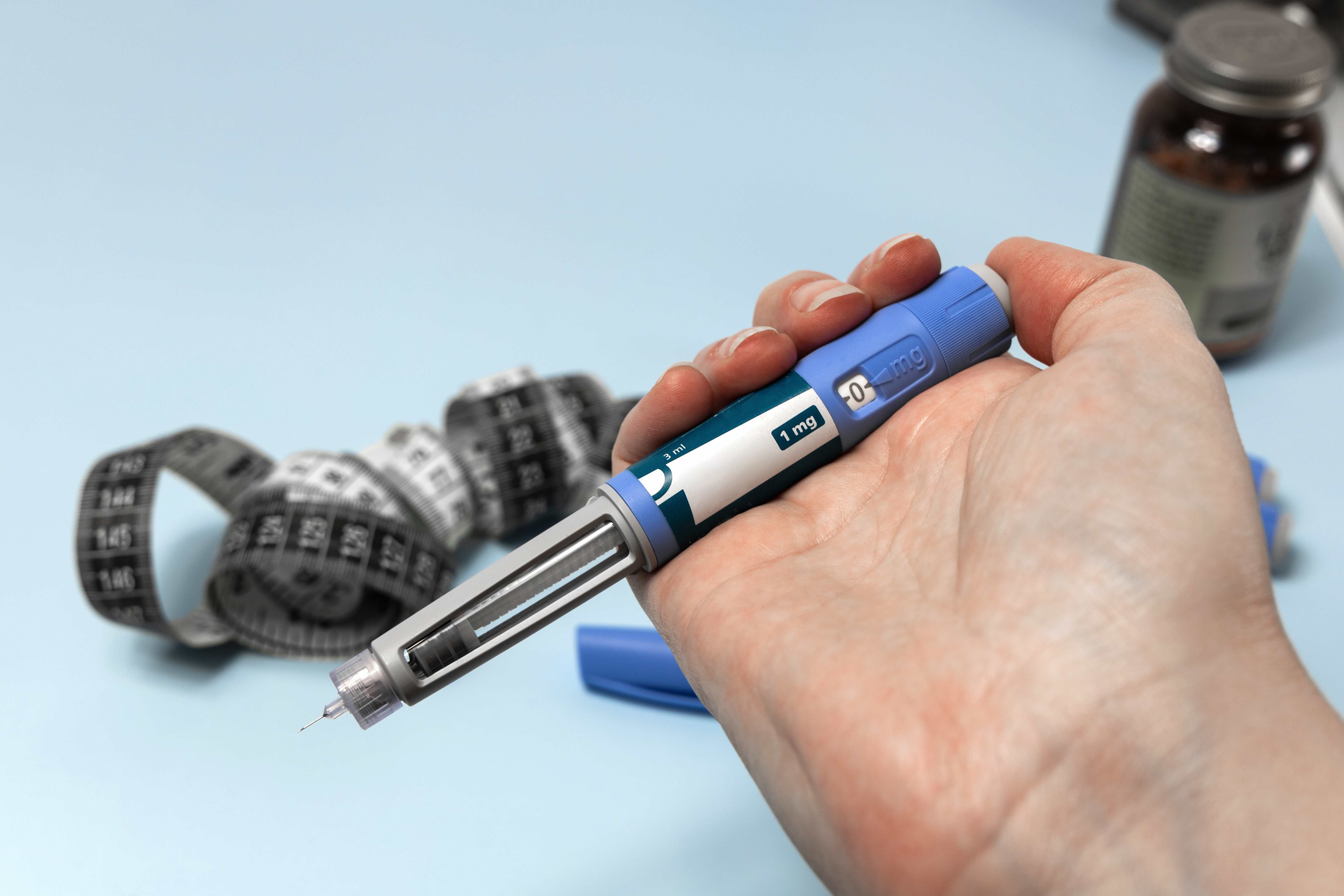Hand holding Ozempic injection pen for diabetes treatment.