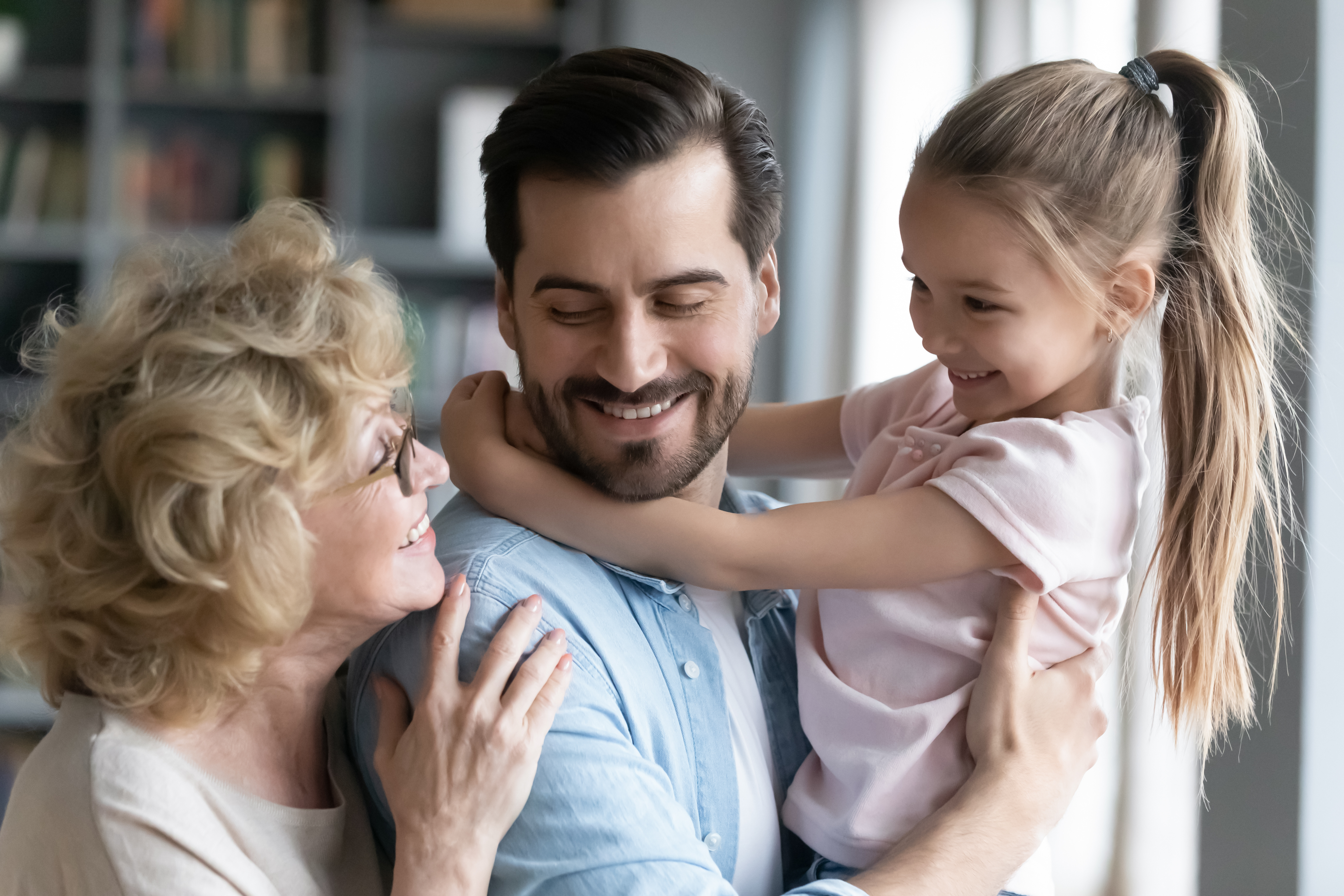 Three generations, grandmother, son and granddaughter, father holding daughter