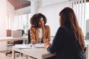 A young woman sits for a job interview.